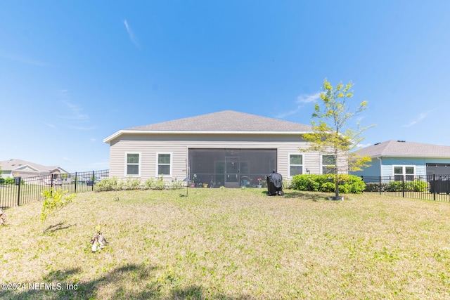 back of property with a lawn and a sunroom