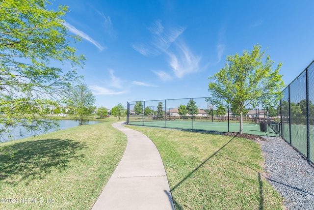 surrounding community with a yard, a water view, and tennis court