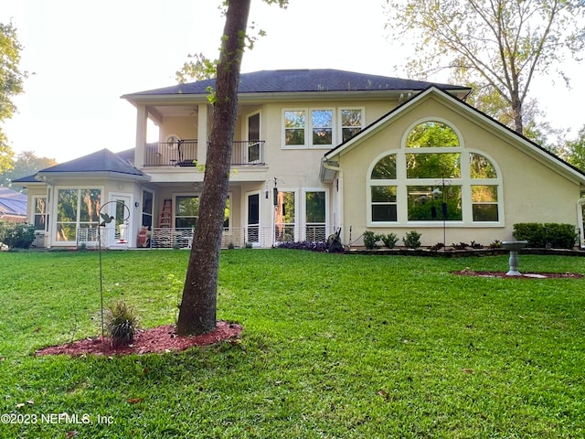 view of front of house featuring a balcony and a front lawn