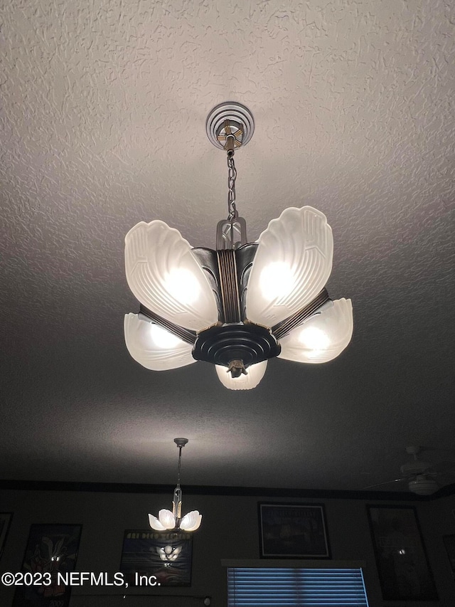 interior details with ceiling fan with notable chandelier