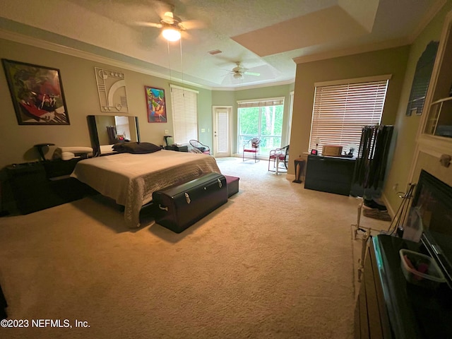 carpeted bedroom featuring ceiling fan, crown molding, a textured ceiling, and a tray ceiling