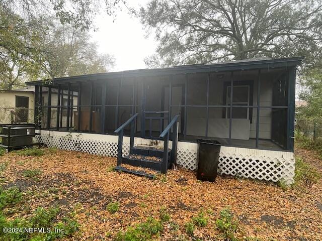 rear view of house featuring a sunroom