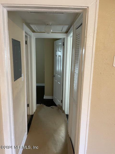 hallway featuring electric panel and concrete floors