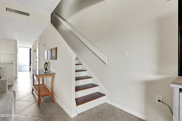 stairway featuring light tile floors