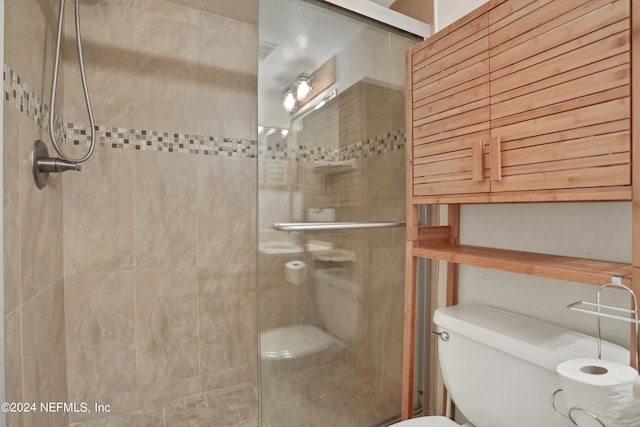 bathroom with toilet and an enclosed shower