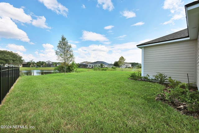 view of yard featuring a water view and fence