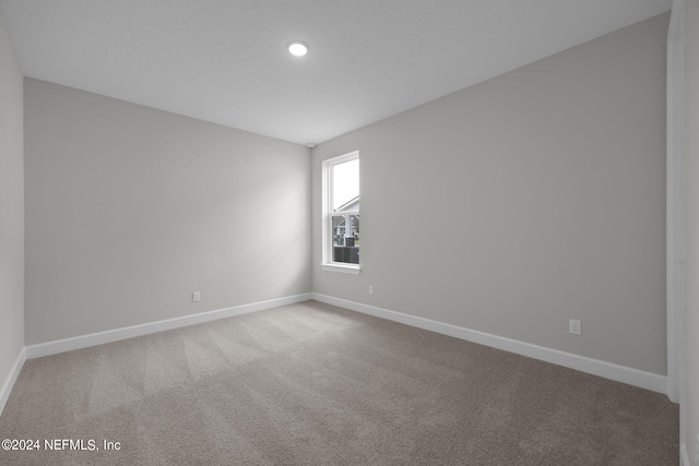 carpeted empty room featuring baseboards