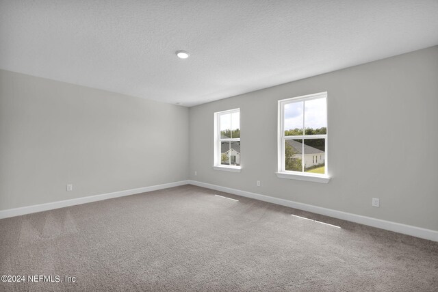 unfurnished room featuring carpet floors, baseboards, and a textured ceiling