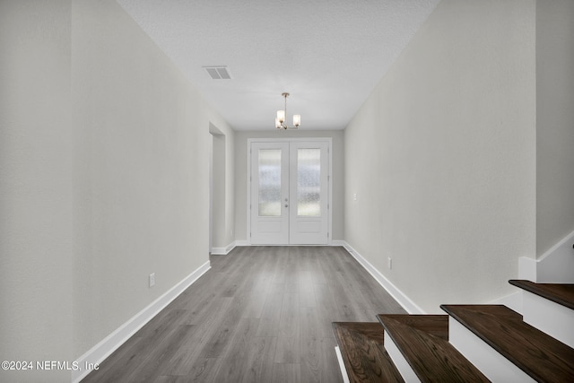 empty room featuring hardwood / wood-style flooring and a chandelier