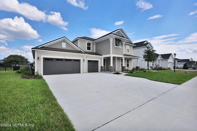 view of front of property featuring a garage, concrete driveway, a front yard, and fence