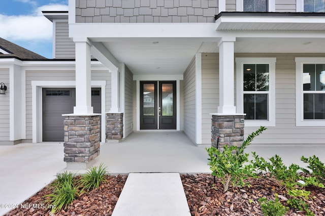 doorway to property featuring a porch and stone siding