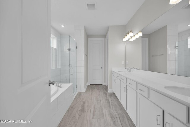 bathroom featuring tile patterned flooring, double sink vanity, and shower with separate bathtub