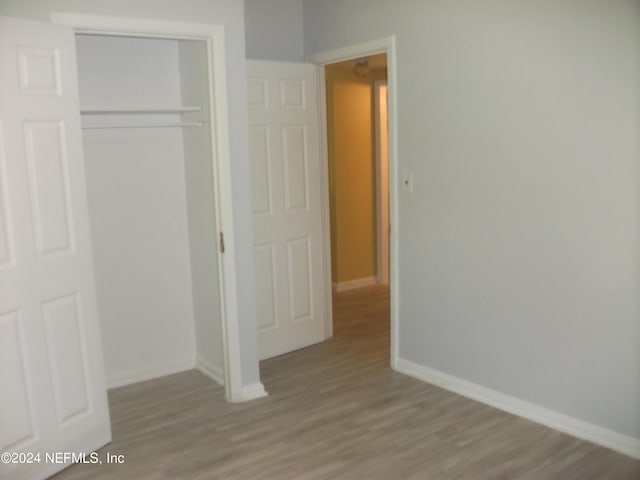 unfurnished bedroom featuring hardwood / wood-style floors and a closet