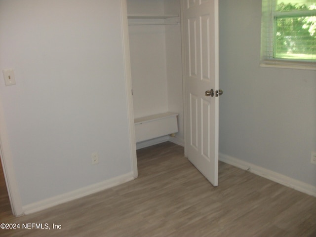 unfurnished bedroom with dark hardwood / wood-style flooring and a closet