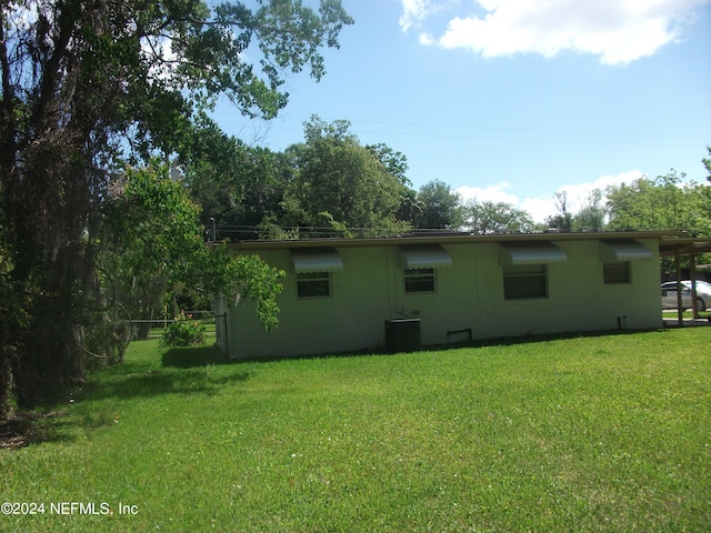 back of house with central AC and a yard