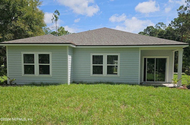 back of property featuring a lawn