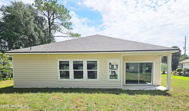 rear view of house featuring a yard