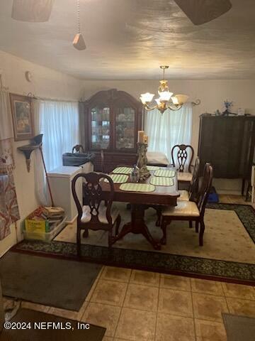 dining room featuring a notable chandelier and tile floors