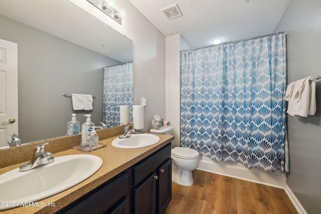 bathroom featuring vanity, a shower with curtain, toilet, a textured ceiling, and wood-type flooring