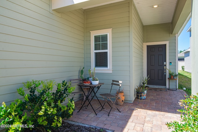 view of exterior entry with a patio area