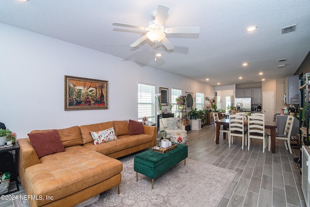 living room featuring a textured ceiling and ceiling fan