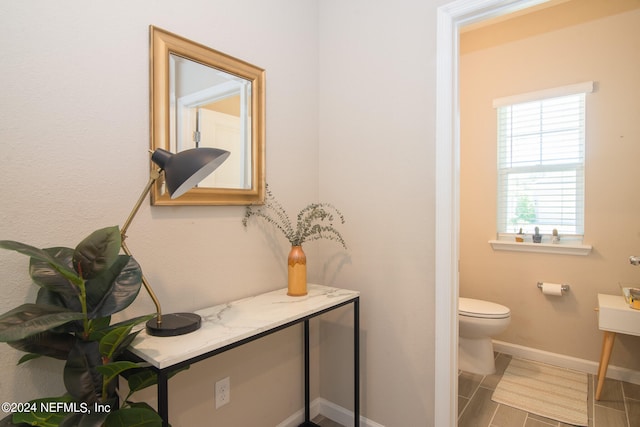 bathroom featuring tile flooring and toilet