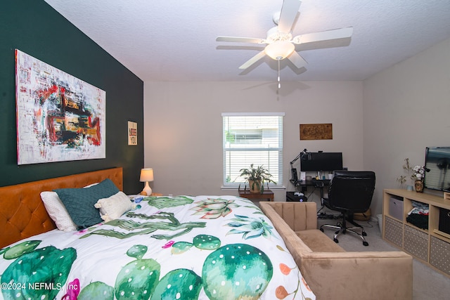 carpeted bedroom featuring ceiling fan and a textured ceiling