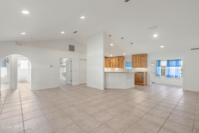 unfurnished living room featuring vaulted ceiling and light tile floors