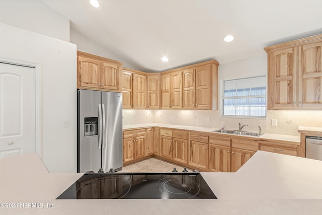 kitchen featuring backsplash, light tile floors, stainless steel fridge with ice dispenser, lofted ceiling, and sink