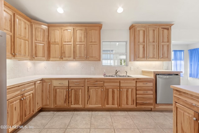 kitchen featuring tasteful backsplash, stainless steel appliances, sink, and light tile floors