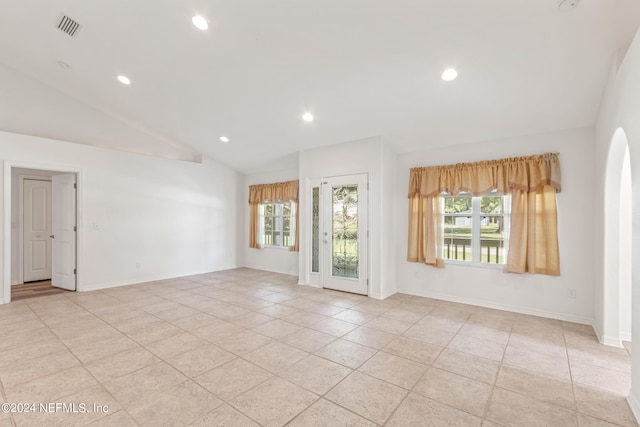 tiled empty room with lofted ceiling