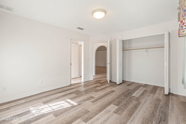 unfurnished bedroom with light hardwood / wood-style floors and a closet