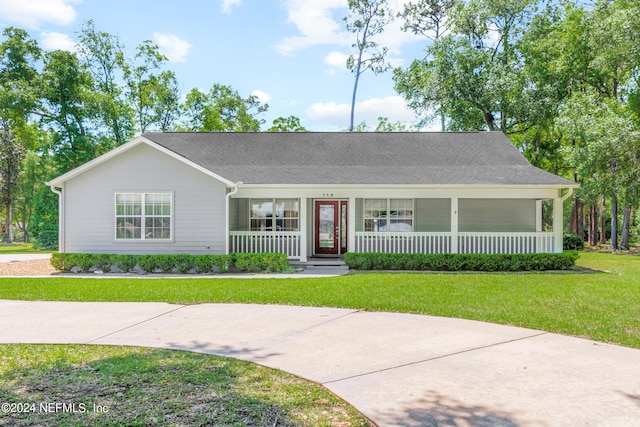 single story home featuring covered porch and a front yard