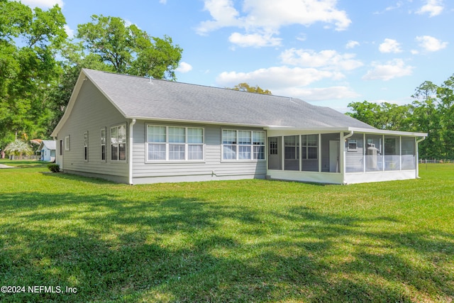 rear view of house with a sunroom and a lawn