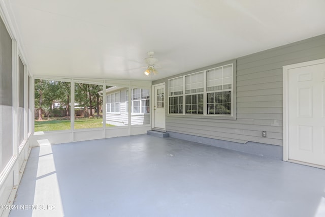 unfurnished sunroom with ceiling fan