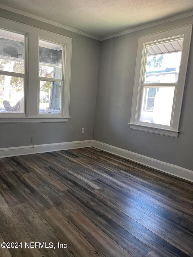 unfurnished room featuring dark wood-type flooring, a healthy amount of sunlight, and ornamental molding