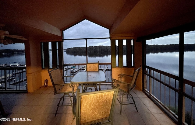 sunroom featuring a water view and lofted ceiling