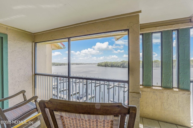 sunroom featuring a water view