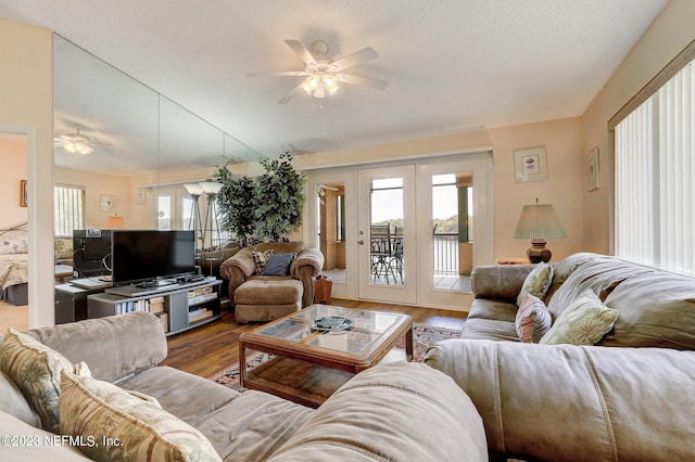 living room featuring french doors, wood-type flooring, and ceiling fan