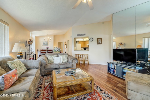 living room with hardwood / wood-style floors, a textured ceiling, and ceiling fan with notable chandelier