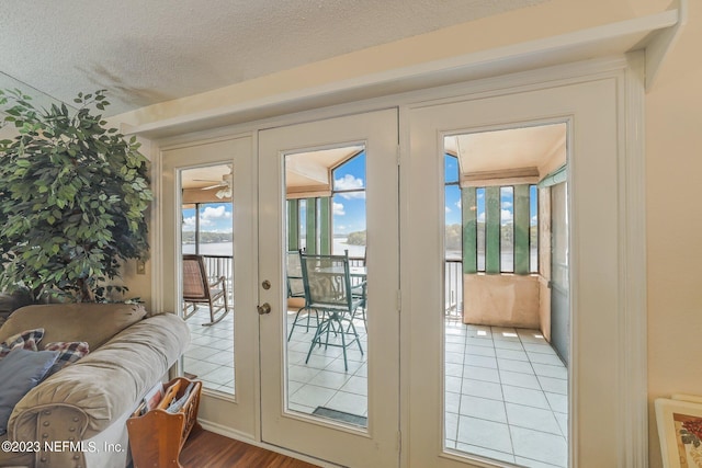 doorway to outside with plenty of natural light, french doors, a textured ceiling, and wood-type flooring