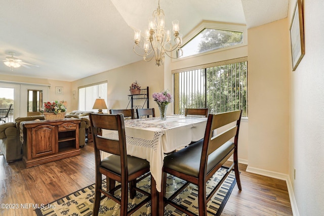 dining space featuring dark hardwood / wood-style floors, ceiling fan with notable chandelier, and lofted ceiling