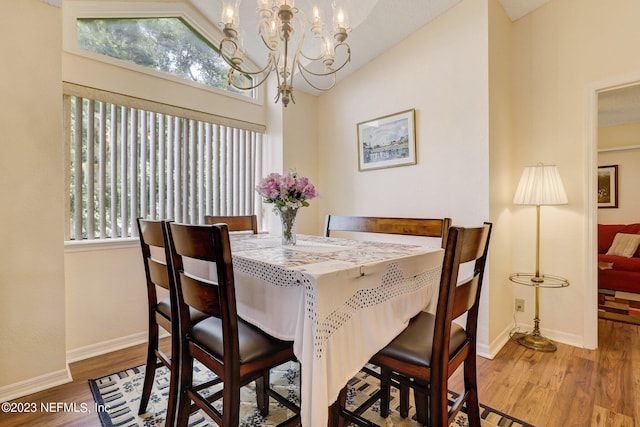 dining room with a chandelier, high vaulted ceiling, and hardwood / wood-style floors