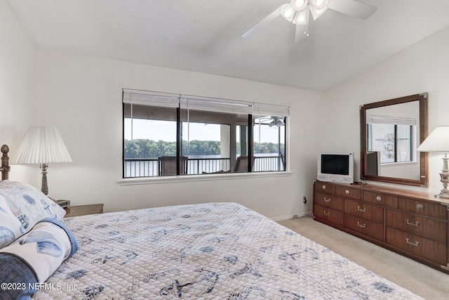 carpeted bedroom with ceiling fan, a textured ceiling, and lofted ceiling