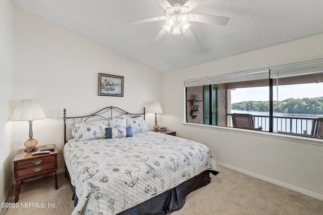 carpeted bedroom featuring a textured ceiling, lofted ceiling, and ceiling fan