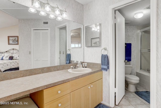 bathroom with tile flooring, vanity, toilet, and a textured ceiling