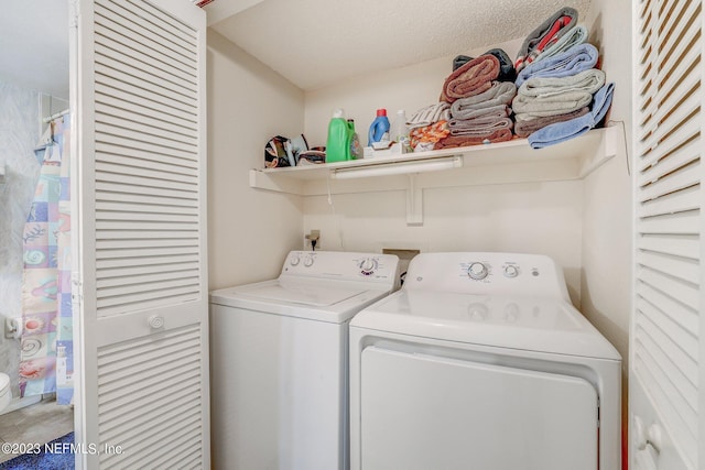 laundry room with washer hookup, washer and dryer, and a textured ceiling