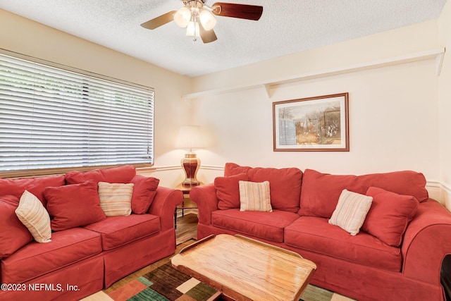 living room featuring a textured ceiling, wood-type flooring, and ceiling fan