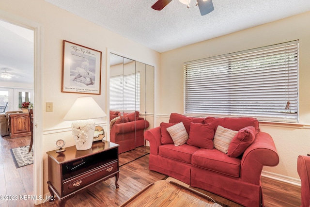 living room featuring plenty of natural light, ceiling fan, a textured ceiling, and wood-type flooring