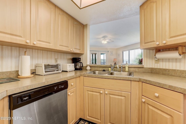 kitchen with ceiling fan, sink, light brown cabinetry, and stainless steel dishwasher